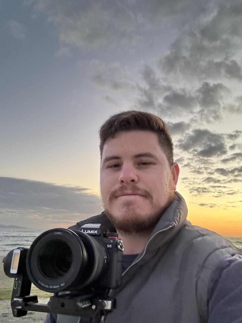 Shaq on location at Waihi Beach at sunset, holding his camera.