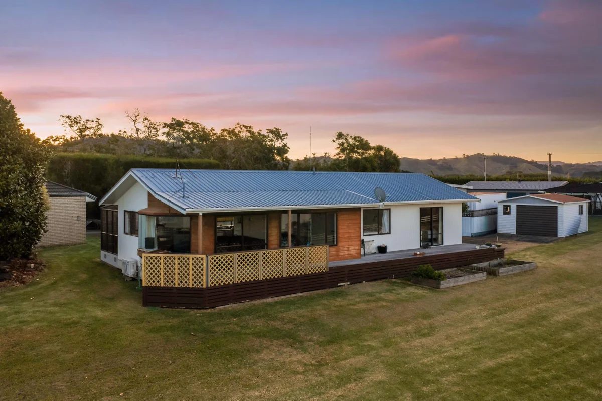 The home at dusk, its deck open to the water