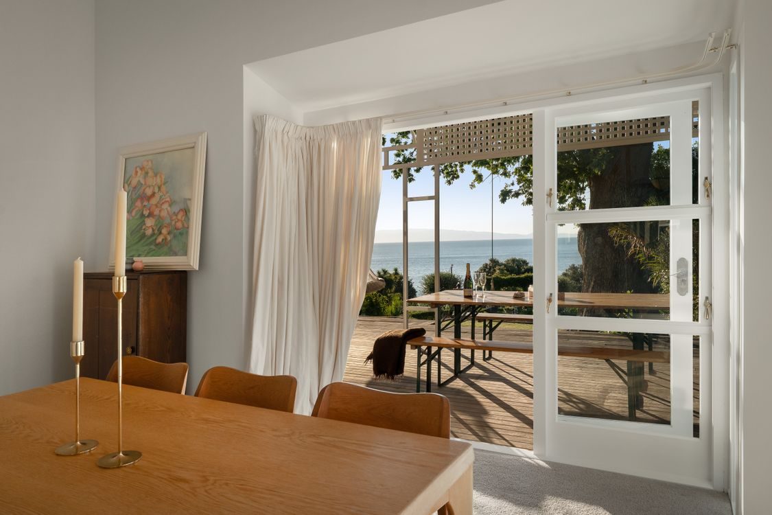 Dining area opening through bifolds to the deck and the view