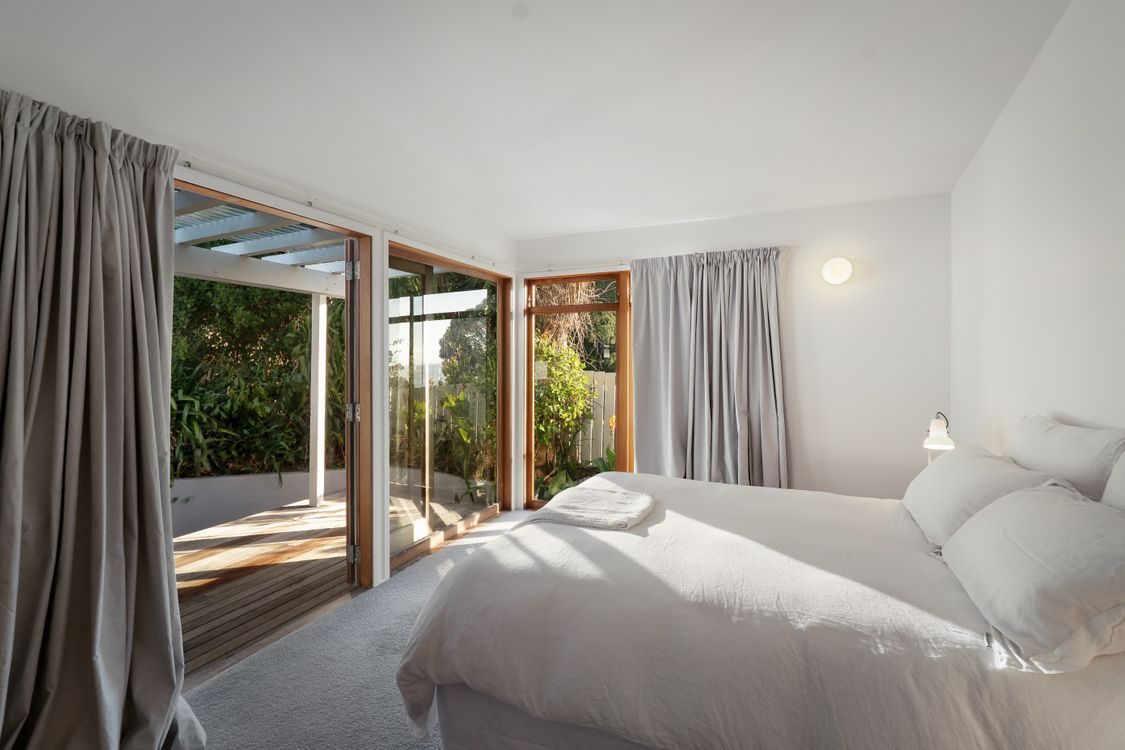 A bedroom opening to the deck and the sea