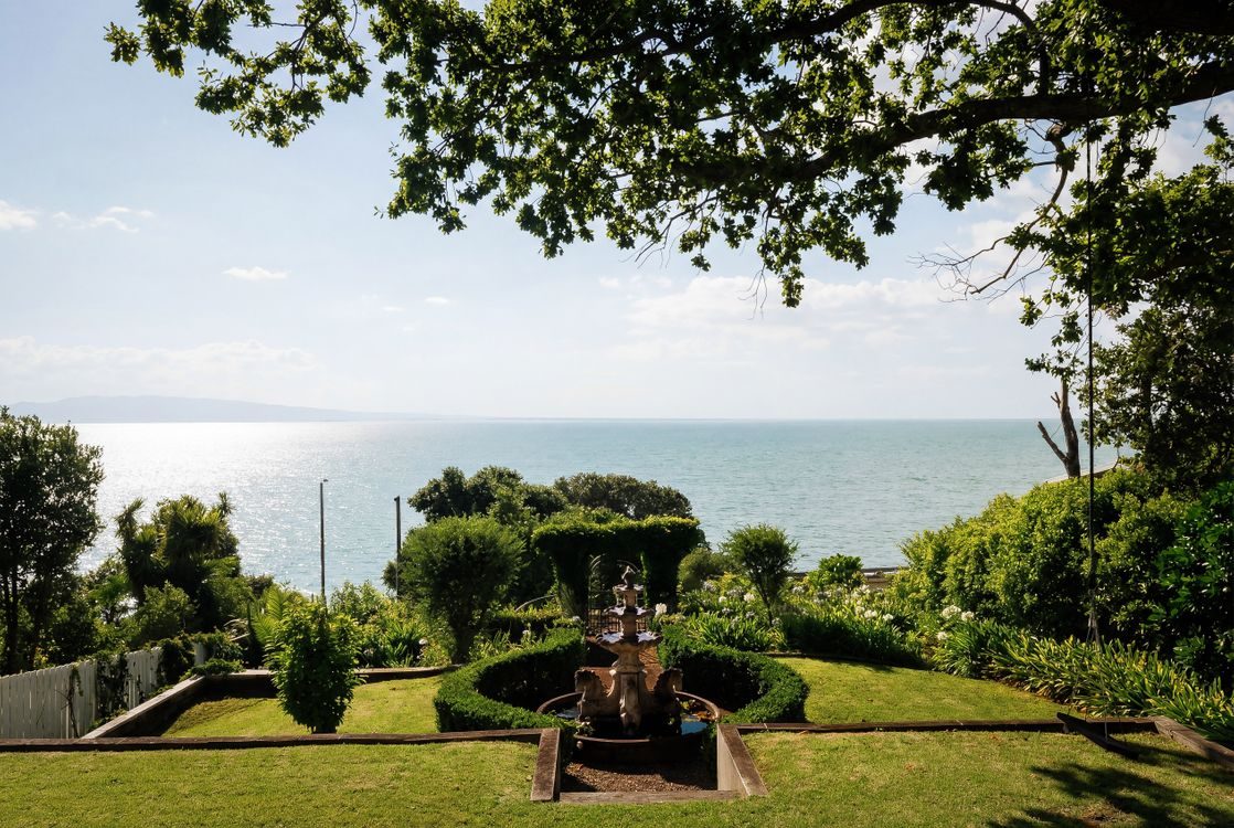 Hedged garden beds with the sea and an island beyond