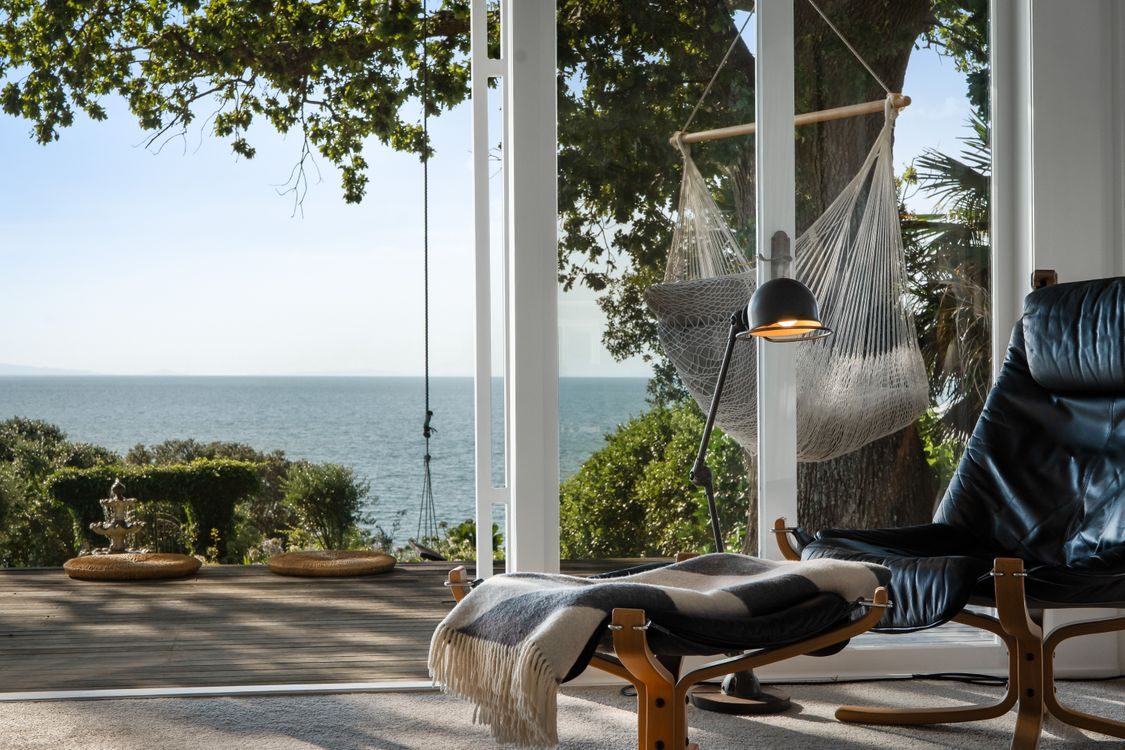 A reading corner with sea views through full-height windows