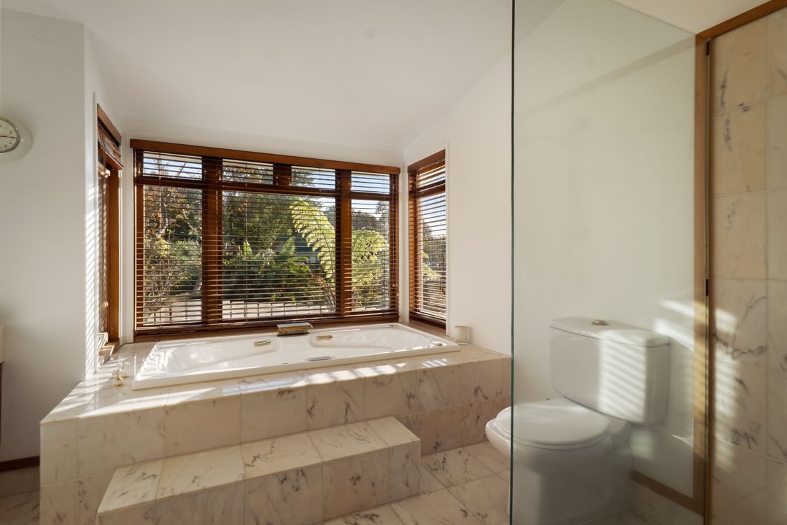 A bathroom with corner windows and timber framing