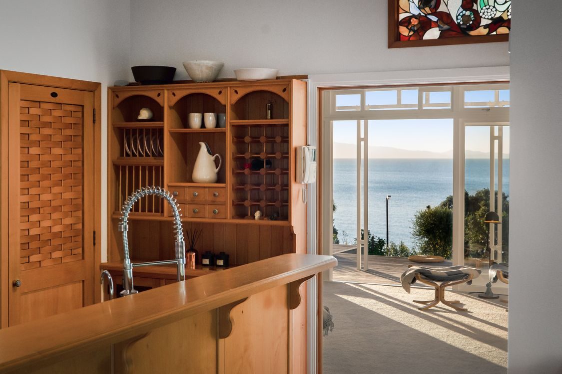 Kitchen with a built-in timber dresser and a window to the sea